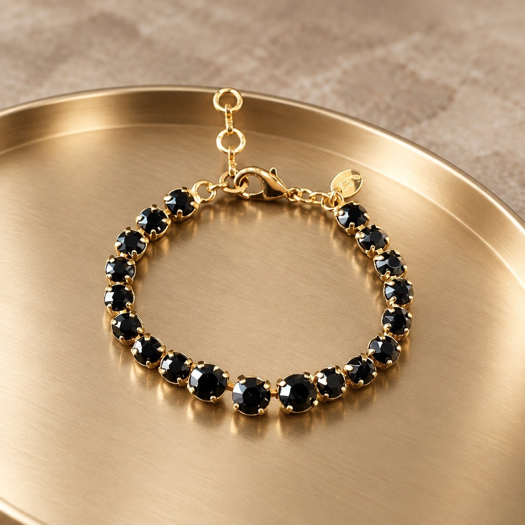 DAMICE Jewelry Blush tennisarmband met zwarte Swarovski-kristallen in gouden zetting op gouden dienblad